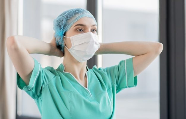Enfermera colocándose su cubre bocas
